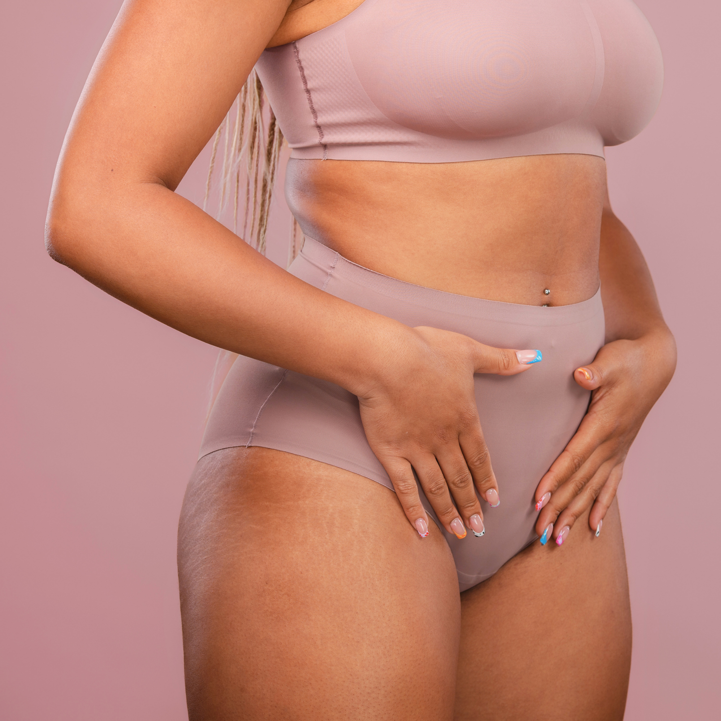 Woman in soft-toned underwear holding her lower abdomen